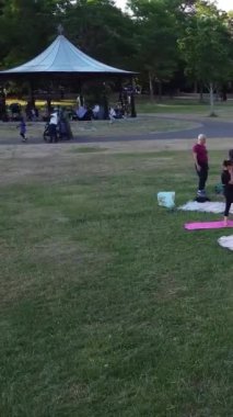 ENGLAND, LUTON TOWN - 04th April 2022: Genç İngiliz Kadınlardan oluşan bir grup, Wardown Halk Parkı Yüksek Açılı Görüntü Parkı 'nda egzersiz yapıyor. Luton Kasabası 'nda Parlak Güneşli Gün