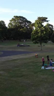 ENGLAND, LUTON TOWN - 04th April 2022: Genç İngiliz Kadınlardan oluşan bir grup, Wardown Halk Parkı Yüksek Açılı Görüntü Parkı 'nda egzersiz yapıyor. Luton Kasabası 'nda Parlak Güneşli Gün