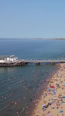 Aerial Footage of people are Relaxing and swimming in the Ocean Water at Beach of Bournemouth England UK