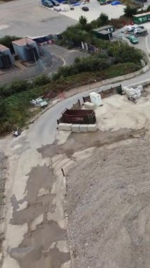 Heavy Duty Machinery and Loader Truck, İngiltere 'nin Luton şehrindeki bir inşaat alanında Digger boyunca çalışıyor. Hava Görüntüsü, İHA 'nın Kamerasıyla 24 Mart 2023' te kaydedildi.