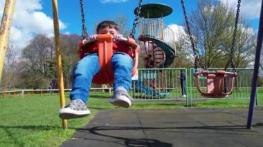 İngiltere, ENGLAND, LUTON - 07th April, 2023: Şirin Asyalı Bebek Ahmet Mustafain Haider Leagrave Park 'taki Çocuk Parkı' nın keyfini çıkarıyor. Görüntü açık güneşli bir günde kaydedildi