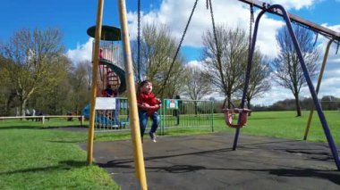 İngiltere, ENGLAND, LUTON - 07th April, 2023: Şirin Asyalı Bebek Ahmet Mustafain Haider Leagrave Park 'taki Çocuk Parkı' nın keyfini çıkarıyor. Görüntü açık güneşli bir günde kaydedildi