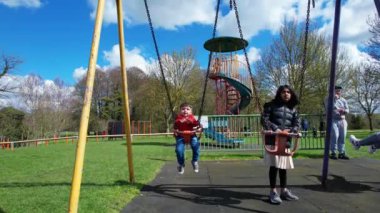 İngiltere, ENGLAND, LUTON - 07th April, 2023: Şirin Asyalı Bebek Ahmet Mustafain Haider Leagrave Park 'taki Çocuk Parkı' nın keyfini çıkarıyor. Görüntü açık güneşli bir günde kaydedildi