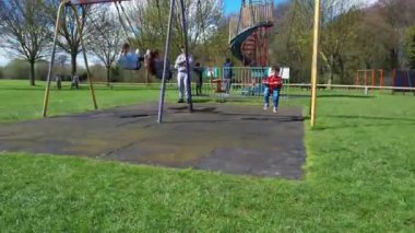 İngiltere, ENGLAND, LUTON - 07th April, 2023: Şirin Asyalı Bebek Ahmet Mustafain Haider Leagrave Park 'taki Çocuk Parkı' nın keyfini çıkarıyor. Görüntü açık güneşli bir günde kaydedildi