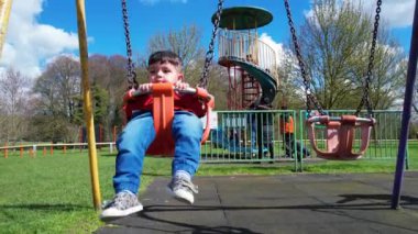 İngiltere, ENGLAND, LUTON - 07th April, 2023: Şirin Asyalı Bebek Ahmet Mustafain Haider Leagrave Park 'taki Çocuk Parkı' nın keyfini çıkarıyor. Görüntü açık güneşli bir günde kaydedildi