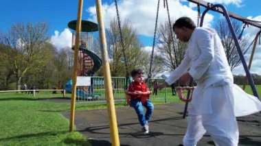 İngiltere, ENGLAND, LUTON - 07th April, 2023: Şirin Asyalı Bebek Ahmet Mustafain Haider Leagrave Park 'taki Çocuk Parkı' nın keyfini çıkarıyor. Görüntü açık güneşli bir günde kaydedildi