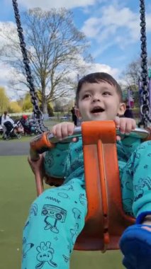 İngiltere, ENGLAND, LUTON - 03RD APRIL, 2023: Şirin Asyalı Bebek Ahmet Mustafain Haider Wardown Halk Parkı 'ndaki Çocuk Parkı' nın keyfini çıkarıyor. Görüntü açık güneşli bir günde kaydedildi