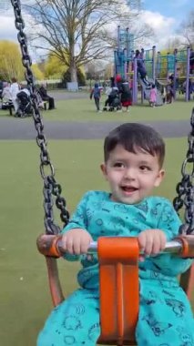 İngiltere, ENGLAND, LUTON - 03RD APRIL, 2023: Şirin Asyalı Bebek Ahmet Mustafain Haider Wardown Halk Parkı 'ndaki Çocuk Parkı' nın keyfini çıkarıyor. Görüntü açık güneşli bir günde kaydedildi
