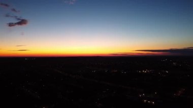 İngiltere 'nin Luton şehrinde güneş doğarken çok az kara bulut ve Orange Sky' ın güzel yüksek açılı görüntüsü.