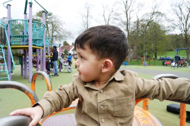 Şirin Asyalı Pakistanlı Bebek İngiltere 'nin Luton kasabasındaki Savaş Parkı' nda eğleniyor.