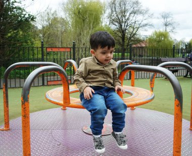 Şirin Asyalı Pakistanlı Bebek İngiltere 'nin Luton kasabasındaki Savaş Parkı' nda eğleniyor.