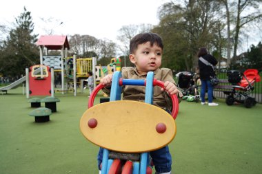 Şirin Asyalı Pakistanlı Bebek İngiltere 'nin Luton kasabasındaki Savaş Parkı' nda eğleniyor.