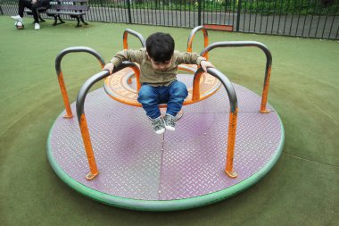 Şirin Asyalı Pakistanlı Bebek İngiltere 'nin Luton kasabasındaki Savaş Parkı' nda eğleniyor.