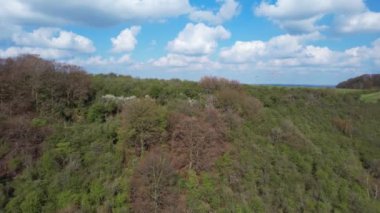 Paragliderler güzel güneşli ve kısmen bulutlu bir günde İngiliz kırsalında uçuyorlar.