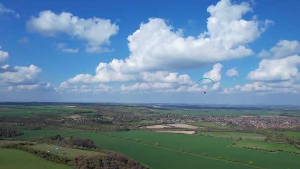 パラグライダーは美しい晴れと部分的に曇りの日に英国の田舎を飛んでいます — ストック動画