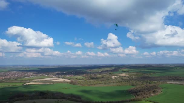 パラグライダーは美しい晴れと部分的に曇りの日に英国の田舎を飛んでいます — ストック動画