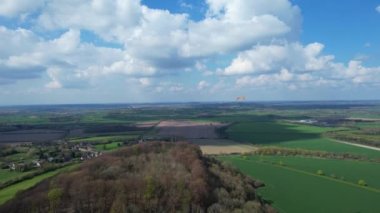 Paragliderler güzel güneşli ve kısmen bulutlu bir günde İngiliz kırsalında uçuyorlar.