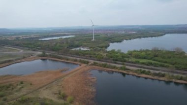 İngiltere 'nin Bedford İngiliz Kırsal Bölgesi' ndeki Stewartby Gölü ve Rüzgâr Türbini Yüksek Açı Görüntüsü. İHA 'nın Yüksek İrtifa Kamerasıyla 23 Nisan 2023' te çekildi.