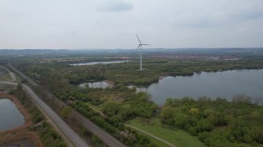 İngiltere 'nin Bedford İngiliz Kırsal Bölgesi' ndeki Stewartby Gölü ve Rüzgâr Türbini Yüksek Açı Görüntüsü. İHA 'nın Yüksek İrtifa Kamerasıyla 23 Nisan 2023' te çekildi.