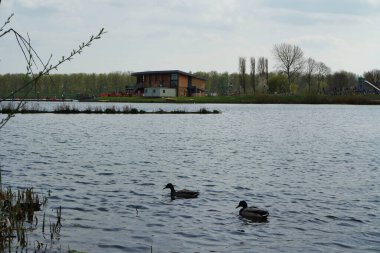 Milton Keynes, İngiltere - 9 Nisan 2023: Willen Gölü 'ndeki insanlar. Willen Lake, Milton Keynes, Buckinghamshire 'da bulunan bir ziyaretçi merkezi.