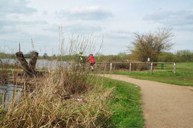 Milton Keynes, İngiltere - 9 Nisan 2023: Willen Gölü 'ndeki insanlar. Willen Lake, Milton Keynes, Buckinghamshire 'da bulunan bir ziyaretçi merkezi.