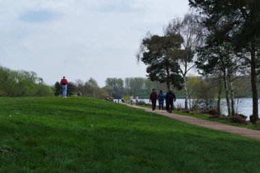 Milton Keynes, İngiltere - 9 Nisan 2023: Willen Gölü 'ndeki insanlar. Willen Lake, Milton Keynes, Buckinghamshire 'da bulunan bir ziyaretçi merkezi.
