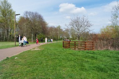 Milton Keynes, İngiltere - 9 Nisan 2023: Willen Gölü 'ndeki insanlar. Willen Lake, Milton Keynes, Buckinghamshire 'da bulunan bir ziyaretçi merkezi.