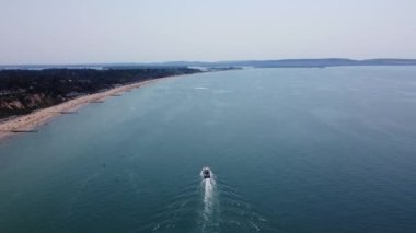 Bournemouth UK Beach ve Ocean 'daki Slow Motion High Angle Moving Sports Boat. Güzel Sıcak Yaz Günü. İnsanlar yaz tatilinin tadını çıkarıyorlar. Görüntü 18-07-2022