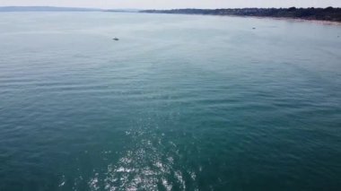 Bournemouth UK Beach ve Ocean 'daki Slow Motion High Angle Moving Sports Boat. Güzel Sıcak Yaz Günü. İnsanlar yaz tatilinin tadını çıkarıyorlar. Görüntü 18-07-2022