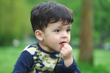 Luton, İngiltere, Birleşik Krallık - 9 Mayıs 2023: bahar parkında sevimli küçük bir çocuk 