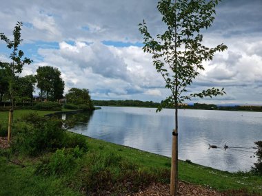 Milton Keynes, İngiltere - 11 Mayıs 2023: Willen Lake Park manzaralı. Willen Lake, Milton Keynes, Buckinghamshire 'da bulunan bir ziyaretçi merkezi.