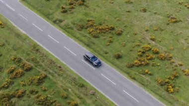 Kırsal Yol 'da Siyah 4x4 MPV Aracın Hava Görüntüsü. İHA 'nın Kamera Görüntüsü ile Yüksek Açı Araba Takibi