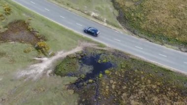 Kırsal Yol 'da Siyah 4x4 MPV Aracın Hava Görüntüsü. İHA 'nın Kamera Görüntüsü ile Yüksek Açı Araba Takibi