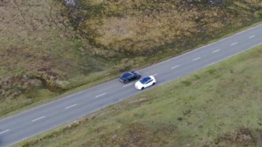 Kırsal Yol 'da Siyah 4x4 MPV Aracın Hava Görüntüsü. İHA 'nın Kamera Görüntüsü ile Yüksek Açı Araba Takibi