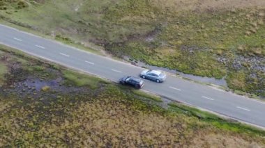 Kırsal Yol 'da Siyah 4x4 MPV Aracın Hava Görüntüsü. İHA 'nın Kamera Görüntüsü ile Yüksek Açı Araba Takibi