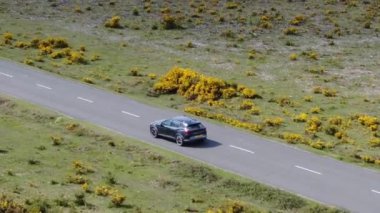 Kırsal Yol 'da Siyah 4x4 MPV Aracın Hava Görüntüsü. İHA 'nın Kamera Görüntüsü ile Yüksek Açı Araba Takibi
