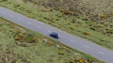 Kırsal Yol 'da Siyah 4x4 MPV Aracın Hava Görüntüsü. İHA 'nın Kamera Görüntüsü ile Yüksek Açı Araba Takibi