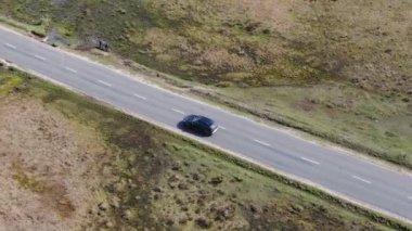 Kırsal Yol 'da Siyah 4x4 MPV Aracın Hava Görüntüsü. İHA 'nın Kamera Görüntüsü ile Yüksek Açı Araba Takibi