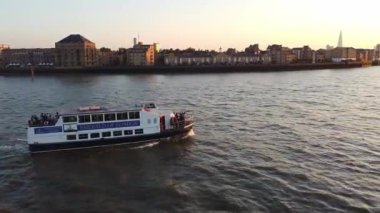 Günbatımında Londra 'nın merkezindeki Thames Nehri' nde tekne. Görüntüler 8 Haziran 2023 'te Canary Wharf London England' da çekildi..
