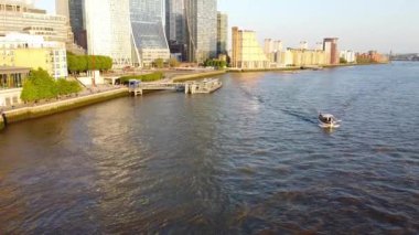 Günbatımında Londra 'nın merkezindeki Thames Nehri' nde tekne. Görüntüler 8 Haziran 2023 'te Canary Wharf London England' da çekildi..