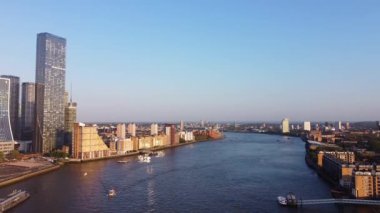 Günbatımında Londra 'nın merkezindeki Thames Nehri' nde tekne. Görüntüler 8 Haziran 2023 'te Canary Wharf London England' da çekildi..