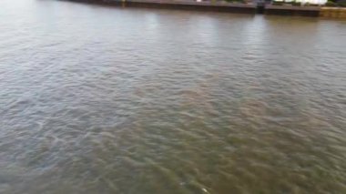 Günbatımında Londra 'nın merkezindeki Thames Nehri' nde tekne. Görüntüler 8 Haziran 2023 'te Canary Wharf London England' da çekildi..