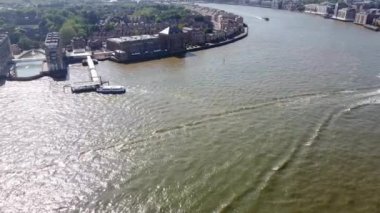 Günbatımında Londra 'nın merkezindeki Thames Nehri' nde tekne. Görüntüler 8 Haziran 2023 'te Canary Wharf London England' da çekildi..