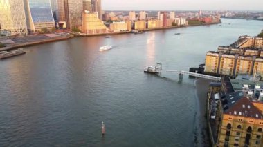 Günbatımında Londra 'nın merkezindeki Thames Nehri' nde tekne. Görüntüler 8 Haziran 2023 'te Canary Wharf London England' da çekildi..