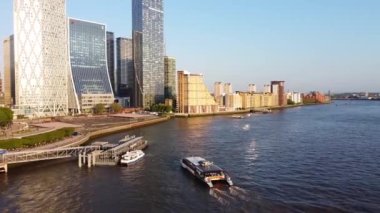 Günbatımında Londra 'nın merkezindeki Thames Nehri' nde tekne. Görüntüler 8 Haziran 2023 'te Canary Wharf London England' da çekildi..