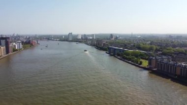 Günbatımında Londra 'nın merkezindeki Thames Nehri' nde tekne. Görüntüler 8 Haziran 2023 'te Canary Wharf London England' da çekildi..