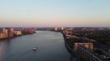 Günbatımında Londra 'nın merkezindeki Thames Nehri' nde tekne. Görüntüler 8 Haziran 2023 'te Canary Wharf London England' da çekildi..