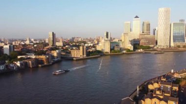 Günbatımında Londra 'nın merkezindeki Thames Nehri' nde tekne. Görüntüler 8 Haziran 2023 'te Canary Wharf London England' da çekildi..