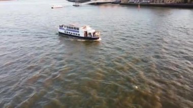 Günbatımında Londra 'nın merkezindeki Thames Nehri' nde tekne. Görüntüler 8 Haziran 2023 'te Canary Wharf London England' da çekildi..