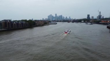 Londra 'nın Thames Nehri' ndeki Feribot Yolcu Kayığı ve İngiltere 'nin Londra Kanarya Rıhtımı Arkasında. Güzel Görüntü İHA 'nın Kamerasıyla 8 Haziran 2023' te çekildi.